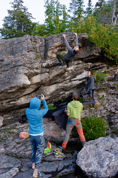 people climbing on the shore of lake huron