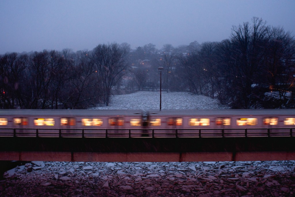 A landscape image of a subway train at dusk.
