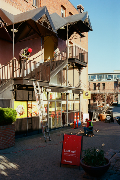 workers hanging lights in downtown victoria