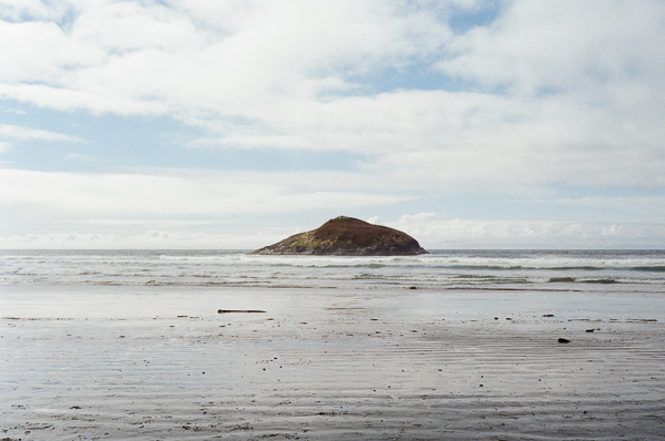A rock in the ocean on long beach